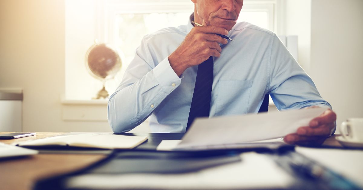 a man reading in a desk filled with other files