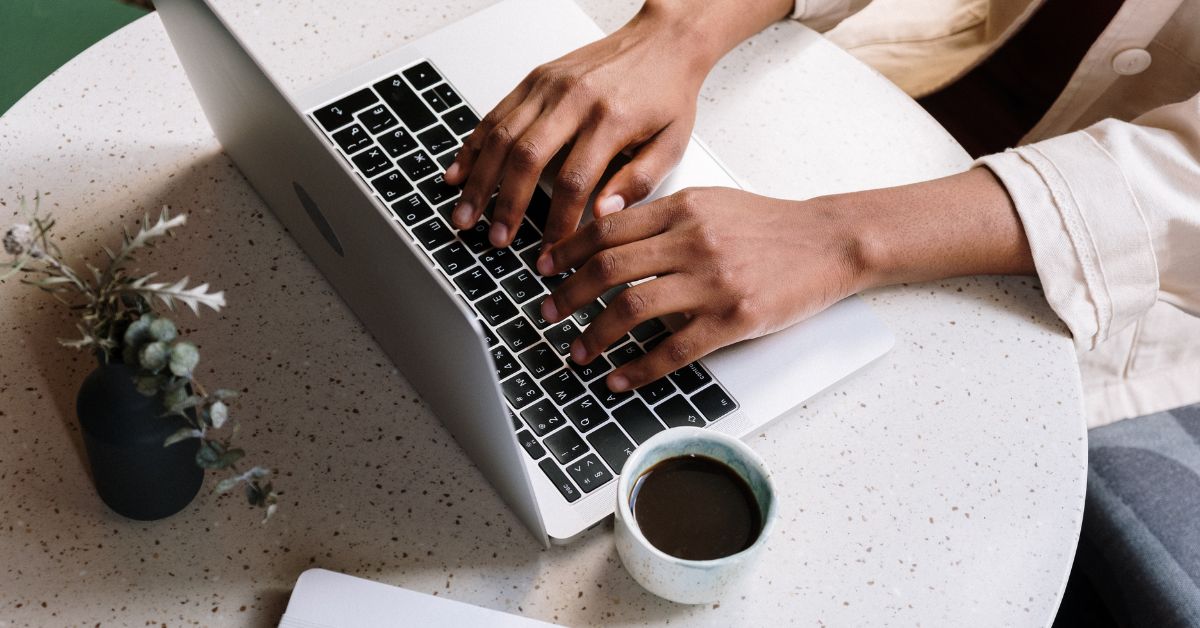 A writer on her desk with plant and coffee