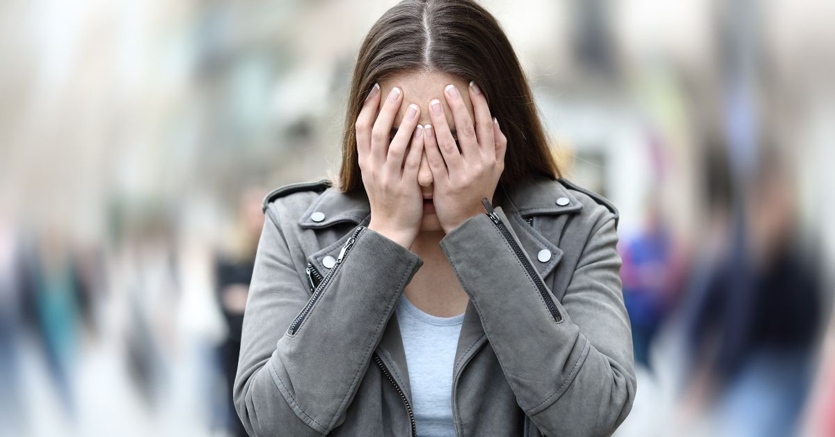 a woman going through an anxiety attack in the middle of a road