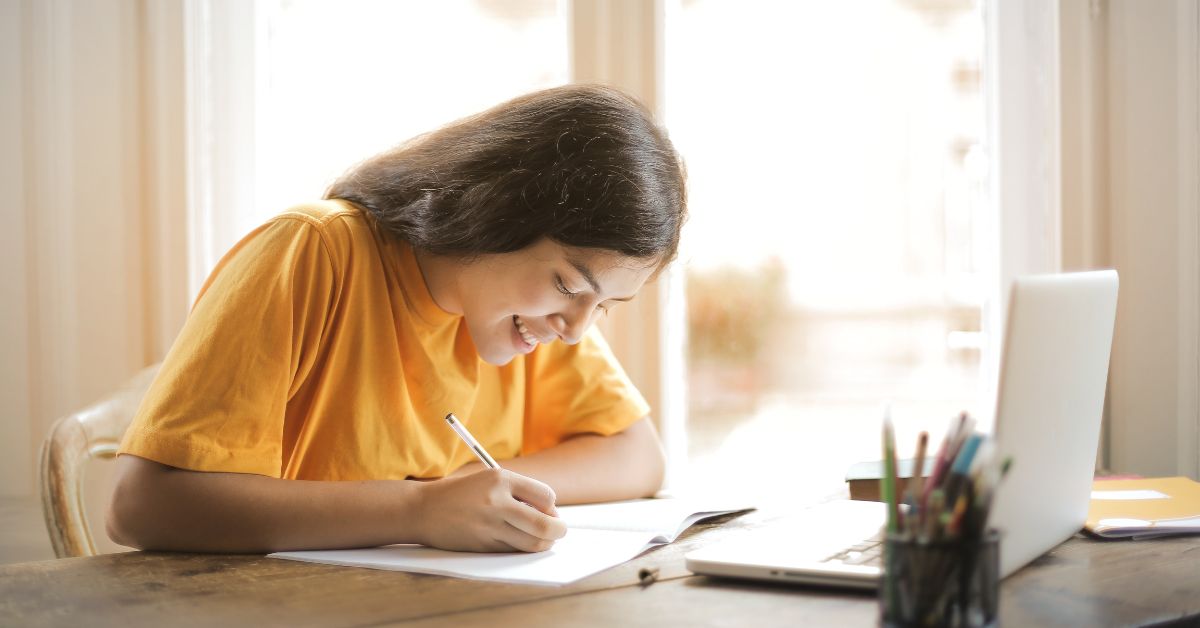 A girl smiling while writing