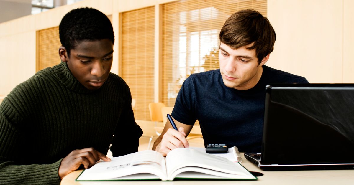 two guys researching through a book