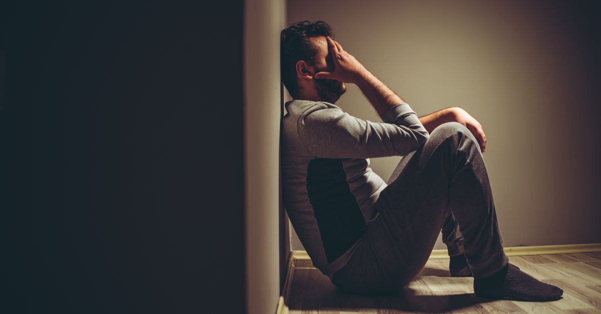 a man sitting down on the floor dealing with depression