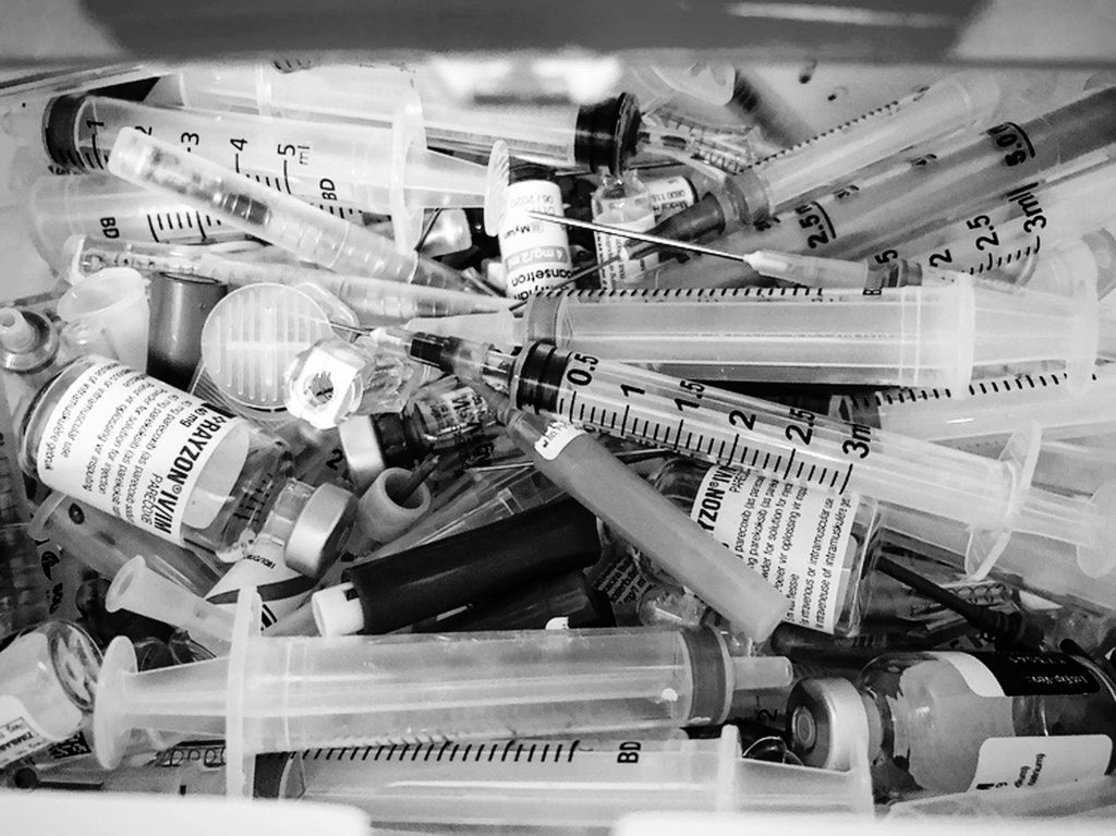 Alt Text: Empty drug vials and syringes used for withdrawal symptoms. Photo via Unsplash.com