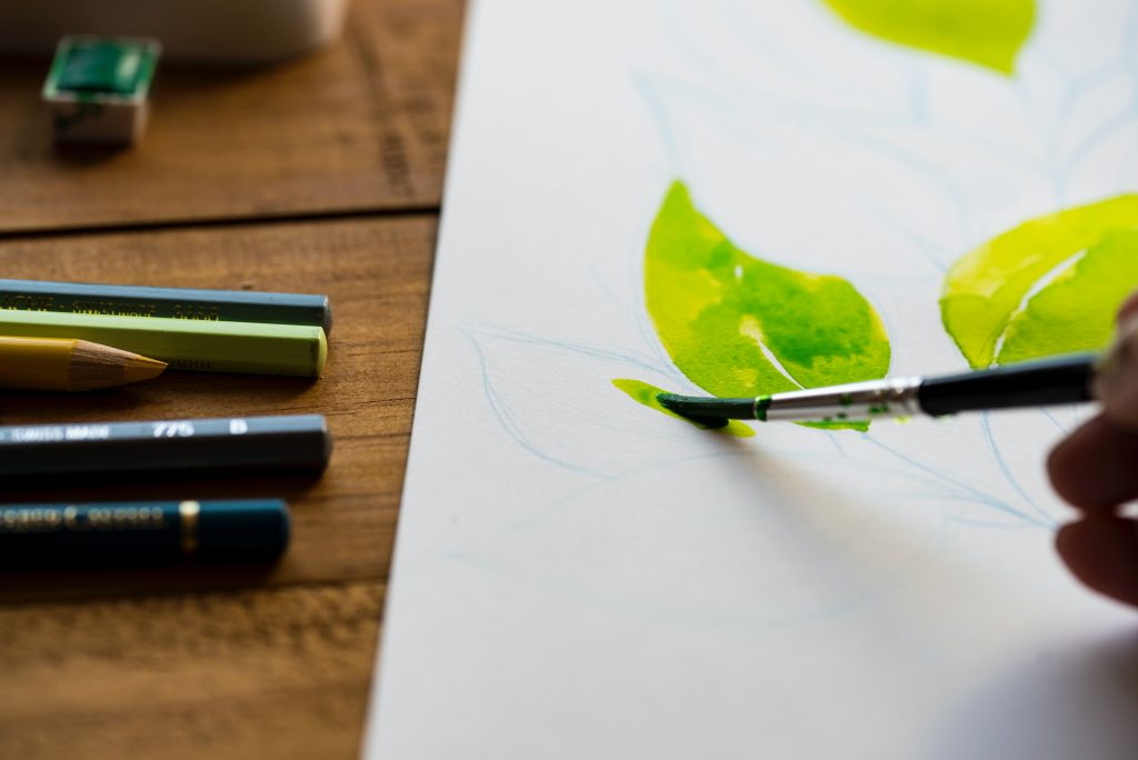 A person brushing paint on a canvas as part of experiential therapy. Photo via Unsplash.