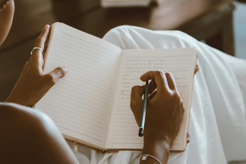 writing on a notebook. Photo by ROMAN ODINTSOV via Pexels