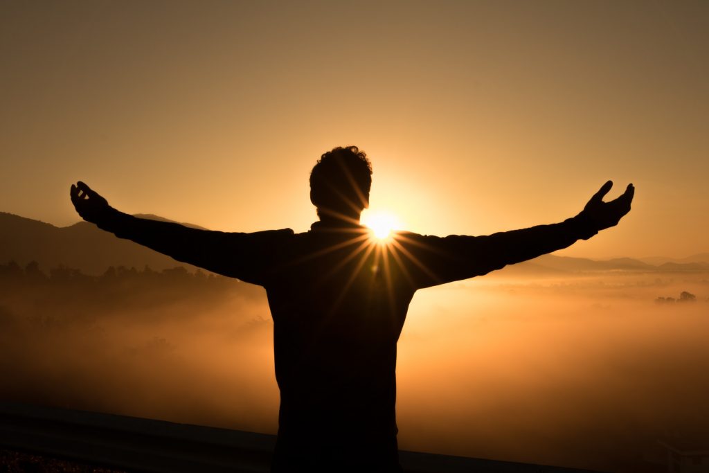ALT TEXT: Man enjoying the sunrise. Photo by Zac Durant via Unsplash